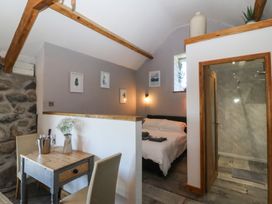 A bedroom with a bed and a shower at Ty Coch in Llanaelhaearn near Trefor, Caernarfon