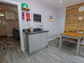 A kitchen with a table and chairs at Y Bwthyn in Llanbedr