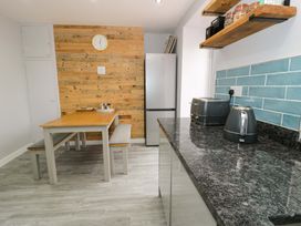 A kitchen with a table and refrigerator at Y Bwthyn Llanbedr