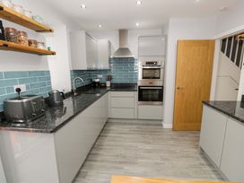 A kitchen with appliances and cabinetry at Y Bwthyn Llanbedr