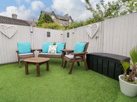 A garden with seating area and artificial grass at Y Bwthyn in Llanbedr