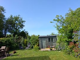 A garden with a shed and seating area at Crooked Well Timsbury, Nr Bath
