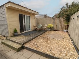 A wooden cabin with outdoor seating at Hazel Cottage in Portrush