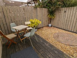 A garden area with a table and chairs at Hazel Cottage in Portrush