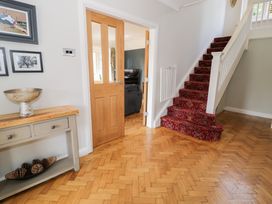 A hallway with a staircase and console table at Pengwern in Llanrwst