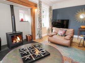 A living room with a wood stove and seating at Pengwern in Llanrwst