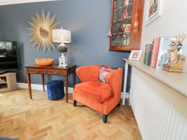 A living room with a side table and a television at Pengwern in Llanrwst