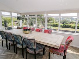A dining room with a large table and colorful chairs at Pengwern in Llanrwst