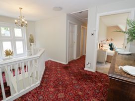 A hallway with a staircase and doorway to a room at Pengwern in Llanrwst