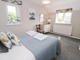 A bedroom with a bed and dresser at Pengwern in Llanrwst