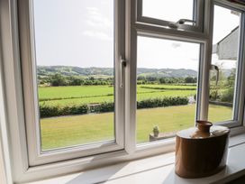 A view from a window showing fields and mountains at Pengwern in Llanrwst