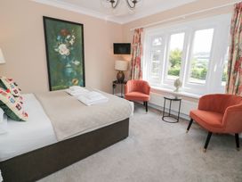 A bedroom with a bed and seating area at Pengwern in Llanrwst
