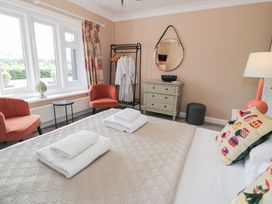 A bedroom with a bed and armchairs at Pengwern in Llanrwst