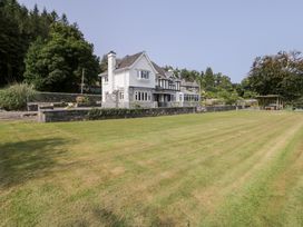 A house with a lawn and trees at Pengwern in Llanrwst