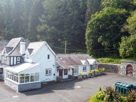 A house with a conservatory surrounded by trees at Pengwern in Llanrwst