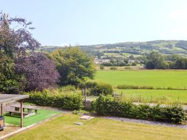 A garden view with trees and a field at Pengwern in Llanrwst