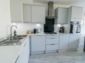 A kitchen with cabinets and appliances at Dune Retreat in Llanfaelog near Rhosneigr