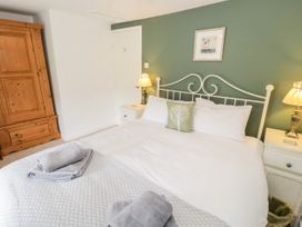 A bedroom with a double bed and bedside tables with lamps at Afallon Penmachno
