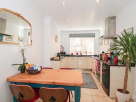 A kitchen with a wooden table and chairs a plant and countertop appliances at The Hideaway in Malvern
