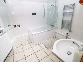 A bathroom with a bathtub, shower, sink, and mirror at The Nook in Star near Cenarth