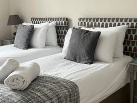 A bedroom with two beds and pillows at Seasides in Weymouth