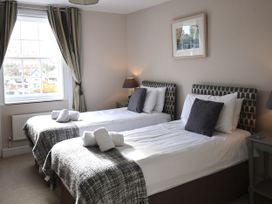 A bedroom with two beds and a window at Seasides in Weymouth