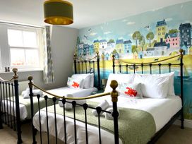 A bedroom with two beds and a mural at Seasides in Weymouth