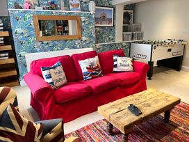 A living room with a red sofa and foosball table at Seasides in Weymouth