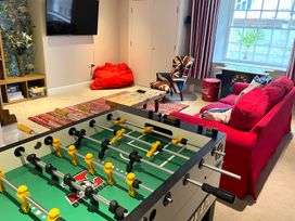 A living room with a foosball table and a television at Seasides in Weymouth