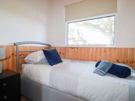 A bedroom with a single bed next to a window and a nightstand with a lamp at 194 Atlantic Bays Atlantic Bays Holiday Park near St Merryn