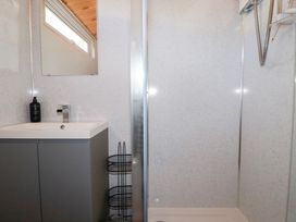 A bathroom with a sink, mirror, shower area, and window at 194 Atlantic Bays Holiday Park near St Merryn