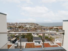 A balcony view overlooking a town and sea at 5 Quay Court in Newquay