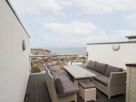 A balcony with outdoor furniture overlooking the ocean at 5 Quay Court in Newquay