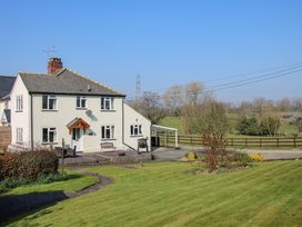 A semi detached house with garden and patio furniture overlooking fields at Belmont Bridge in Henlle