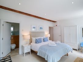 A bedroom with a bed and wardrobe at 9 The Pottery in Dartmouth