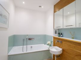 A bathroom with a bathtub and sink at 9 The Pottery in Dartmouth