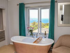 A bathroom with a bathtub and window view at Voebroch in Lythe