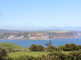 A coastal view featuring water, cliffs, and houses at Voebroch in Lythe