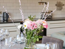 A dining room table set with flowers and wine glasses at Voebroch in Lythe