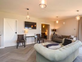 A living room with a television and seating at Voebroch in Lythe