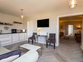A living room with kitchen units and a television at Voebroch in Lythe