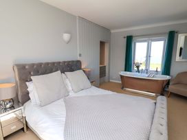A bedroom with a bed and bathtub at Voebroch in Lythe