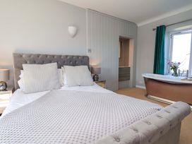 A bedroom with a bed and a bathtub at Voebroch in Lythe