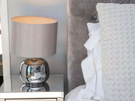 A bedroom with a lamp and pillows on a bedside table at Voebroch in Lythe