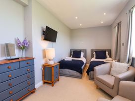 A bedroom with two beds and a television at Voebroch in Lythe