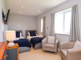 A bedroom with two beds and an armchair at Voebroch in Lythe