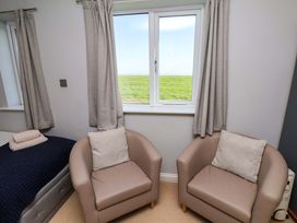 A bedroom with two armchairs and a window at Voebroch in Lythe