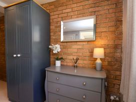A bedroom with a grey wardrobe and dressing table at Voebroch in Lythe
