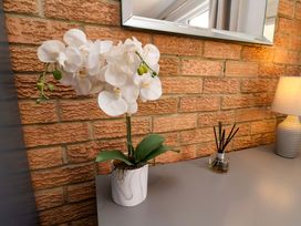 A table with a flower, a mirror, and a lamp at Voebroch in Lythe
