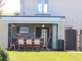An outdoor dining area with a table and chairs at Voebroch in Lythe